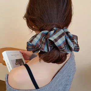 Classic blue and brown plaid fabric scrunchie styled on a bun hairstyle in daily life