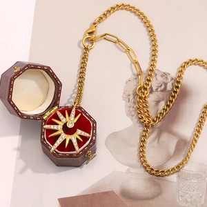 Detail view of 18K gold plated starburst tassel necklace in a red velvet jewelry box