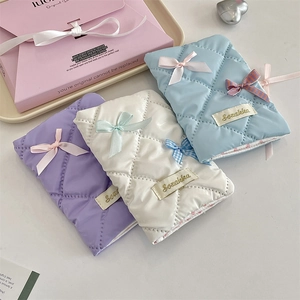 Quilted bow passport holders in pastel colors on a stylish gift display tray