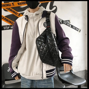 Street style shot of a black quilted nylon crossbody bag with adjustable strap