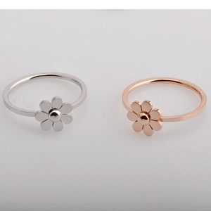 Close-up of silver and rose gold sunflower rings with minimalist polished bands