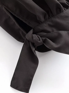 Detailed view of the black bow-tie knot and twill fabric texture on these casual pants