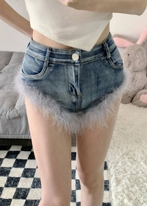 Nahaufnahme von blauen High-Waist-Denim-Shorts mit lavendelfarbenem Federbesatz