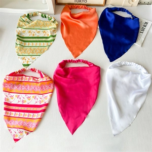 Selection of vibrant elastic satin bandanas with floral prints and solid colors on white back
