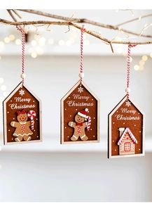 Close-up of three felt gingerbread man ornaments hanging on a festive Christmas tree