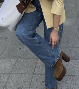 Close-up of straight-leg denim jeans in dark blue paired with brown platform boots