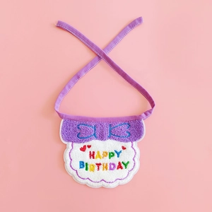 Close-up of purple and white pet birthday bib with colorful Happy Birthday embroidery