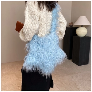 Close-up of light blue plush crossbody bag with soft faux fur texture on a model