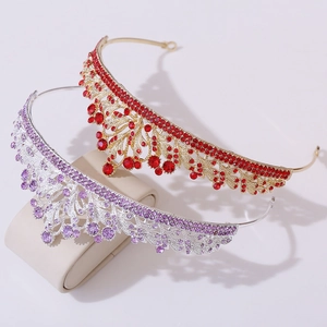 Elegant bridal tiaras in gold with red stones and silver with purple crystals on display