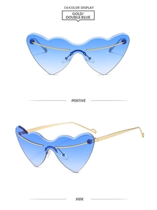 Close-up of heart-shaped rimless sunglasses with blue gradient lenses and gold metal frame