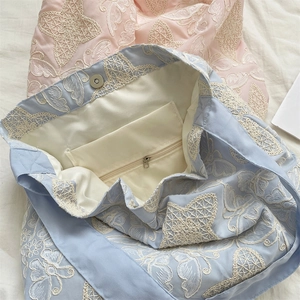 Détail du sac brodé montrant la doublure intérieure, poche zippée et fermoir magnétique
