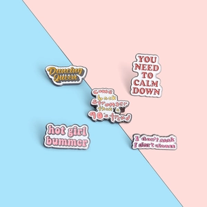 Close-up of colorful enamel pin set with pop culture quotes on pastel background