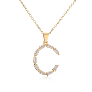 Detailed close-up of 18K gold-plated necklace with C-shaped zircon pendant on white surface