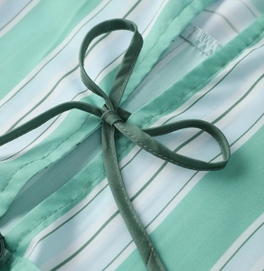 Détail du tissu à rayures menthe et blanc avec un nœud papillon noué à la taille