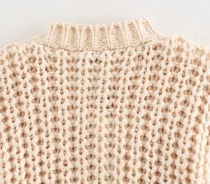 Detail of beige chunky knit cardigan showing high-quality rib texture and stitching