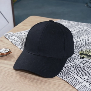 Detailed view of a classic black cotton baseball cap on a wooden table with lifestyle props