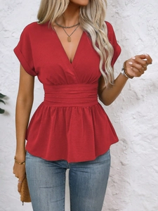Close-up of red V-neck top featuring waist pleats and elegant ruffle hem detail