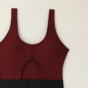 Detail of burgundy and black color block swimsuit with hollow out waist and U-neckline