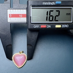 Detailed measurement of heart-shaped gold pendant with pink stone showing 16.2 mm width