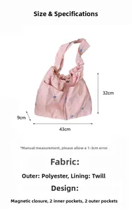 Detailed spec view of a pink embroidered handbag with size 43x32x9cm and magnetic closure
