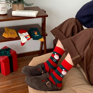 Close-up of festive Christmas crew socks featuring Santa and gingerbread man patterns