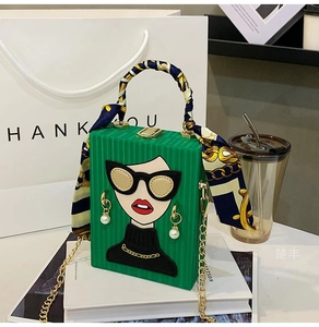 Detail of green box evening bag with pop art portrait and silk scarf handle detail