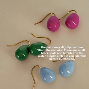 Detail of teardrop enamel earrings in pink, green and blue with gold plated hooks
