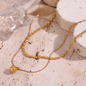 Detail of 18K gold-plated double-layer necklace with beads and a solid sphere pendant