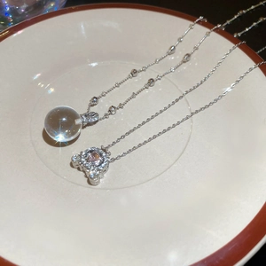 Close-up of sparkling heart-shaped pink crystal and clear round pendant necklaces