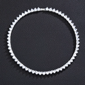 Silver tennis chain necklace with heart-shaped sparkling zircons on black leather surface