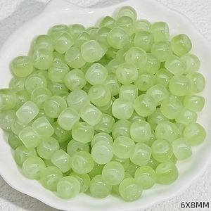 Detail of 6x8mm light green translucent faux jade beads in a white shell-shaped bowl