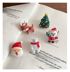 Detailed macro shot of festive resin Christmas charms on vintage book pages for DIY crafts