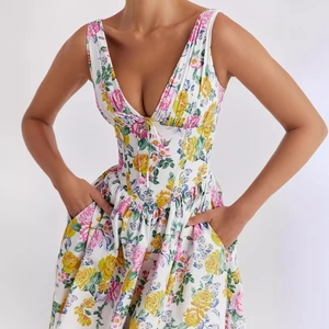 Elegant V-neck sleeveless floral dress with side pockets and a slim waistline for summer
