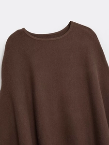Detail of deep brown knit poncho showing refined neckline and textured fabric stitching