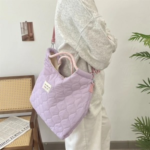 Gros plan du sac fourre-tout matelassé violet clair avec des sangles roses