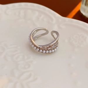 Macro view of triple-layered silver ring with white pearls and micro-set cubic zirconia