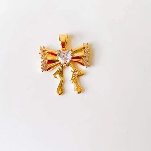 Detail of 18k gold butterfly pendant with heart-shaped crystal and small round stones