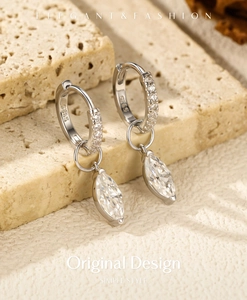 Macro shot of S925 sterling silver marquise cut moissanite earrings on stone base