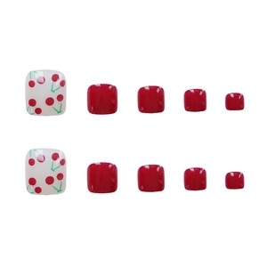 Sweet red cherry pattern and solid red color press-on toenails on a clean white background