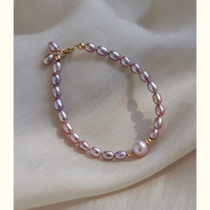 Elegant lavender freshwater pearl bracelet with 14K gold beads on beige silk background