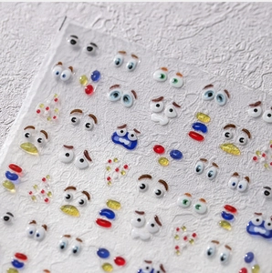 Detailed view of 3D cartoon eyes and geometric resin nail stickers on transparent film