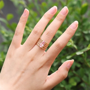 Dettaglio di un anello multistrato dorato con zircone rosa dal taglio marquise chic