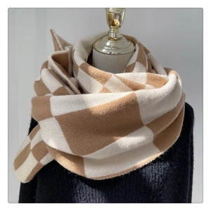 Detail shot of the thick knitted texture and khaki checkered pattern of the scarf
