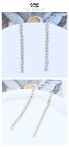Dettaglio degli orecchini a nappa con strass oro e argento con design geometrico a S