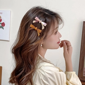 2-piece acetate bow hair clips set in pink and brown marble patterns worn by a model