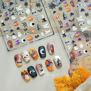 Detail of Halloween nail stickers featuring pumpkins, ghosts, and bats in orange and black