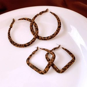 Detail of round and square leopard print earrings with a soft flocked velvet texture