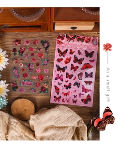 Macro detail of red rose and butterfly themed vintage PET stickers for journaling