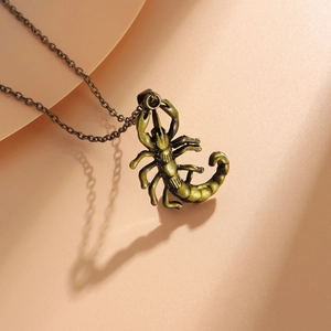 Detailed macro view of a vintage bronze scorpion pendant with textured metallic chain link