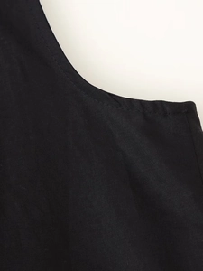 Detailed close-up of V-neck stitching and black cotton-linen fabric texture on women's top